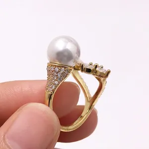 Detailansicht eines luxuriösen Goldrings mit großer weißer Perle und funkelndem Zirkon