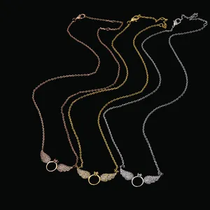 Three angel wing necklaces in gold, silver, and rose gold with pavé crystals on black background