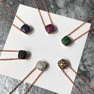Détail des pendentifs carrés à motif nid d'abeille sertis de pierres colorées