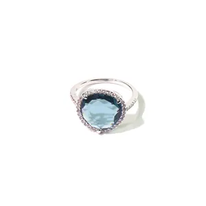 Detailansicht eines Silberrings mit birnenförmigem blauem Edelstein und Diamantkranz