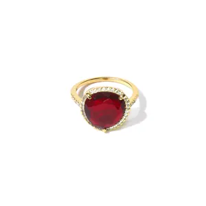 Vue macro détaillée de la pierre rouge et du micro-pavage de cristaux sur la bague dorée