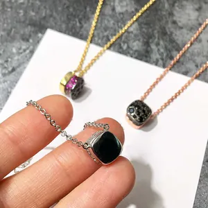 Vue détaillée de colliers géométriques carrés avec pierres colorées et pendentifs en pavé