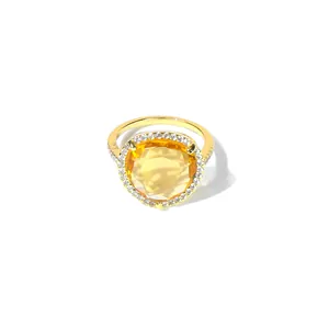 Gros plan d'une bague dorée avec pierre jaune taille poire et sertissage de zircons