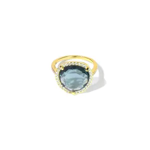 Bague classique plaquée or avec un grand cristal bleu entouré d'un halo de zircons