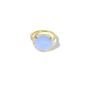Bague élégante en or avec une grande pierre bleu clair triangulaire et halo de zircons