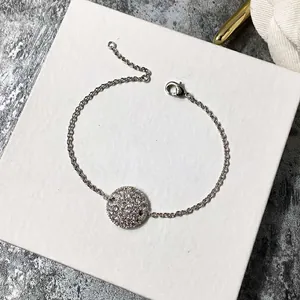 Vue détaillée d'un bracelet en argent avec un pendentif circulaire orné de cristaux brillants