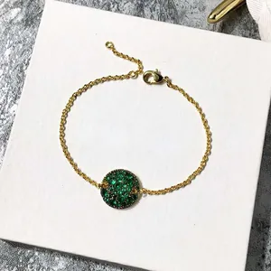 Détail du bracelet doré avec pendentif champignon en cristaux verts étincelants