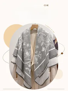 Dettaglio della sciarpa spessa in cashmere vintage con fiori su un cappotto beige