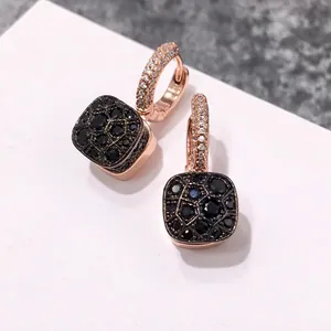 Détails de boucles d'oreilles carrées en or rose avec pavé de pierres noires motif ruche