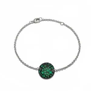 Détail de gourmette argentée avec pendentif champignon pavé de cristaux verts et noirs