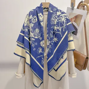 Dettaglio dello scialle blu scuro e beige con stampa floreale e bordi rifiniti