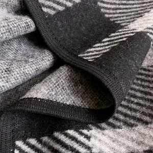 Close-up of thick plaid cashmere shawl showing premium texture and neat black edging