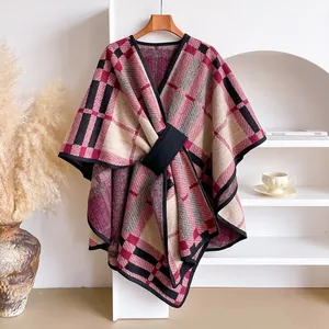 Detail of red and black plaid poncho cape with crossover design and waist buckle