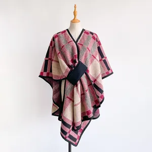 Detail of red and pink plaid shawl wrap with a cross-insert closure and black hem