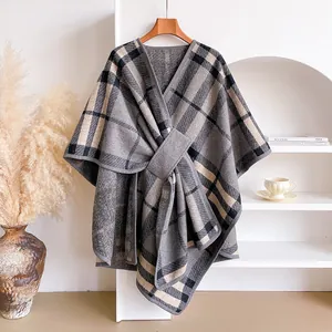 Close-up of gray plaid knit shawl wrap featuring a waist buckle and soft texture