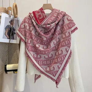 Detailansicht von rot-weißem Strickschal mit geometrischem Muster und feinen Fransen