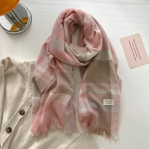 Detail of pink plaid wool blend scarf showing fringe edges and fabric texture