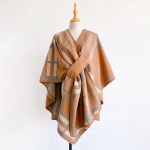 Close-up of warm brown plaid shawl fabric texture with a wide decorative strap