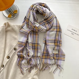 Detail of soft purple and yellow plaid winter scarf with fringe and brand label