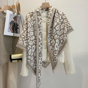 Dettaglio di scialle invernale leopardato con frange abbinato a giacca in tweed