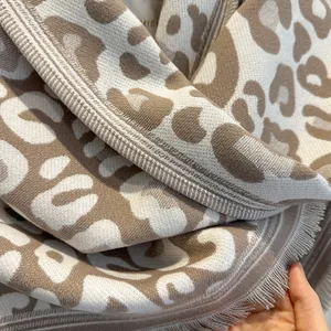 Dettaglio dello scialle invernale leopardato in maglia morbida con rifiniture a frange