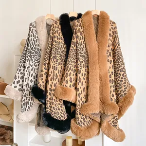Three leopard print knit capes with faux fur collars hanging in a cozy interior setup