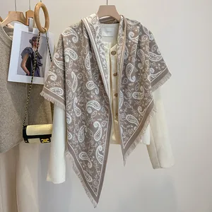 Detail view of coffee-colored paisley bandana scarf with fringes on white coat