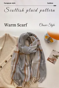 Detail of Scottish plaid wool scarf with fringes in grey, beige and caramel tones