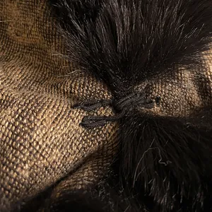 Detailed close-up of metallic leopard knit shawl with faux rabbit fur trim and black tie knot