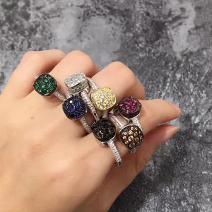 Detalle de anillos cuadrados con circonitas de colores y piedras verde esmeralda