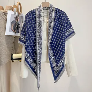 Detailed close-up of navy blue geometric diamond jacquard shawl with soft fringe trim