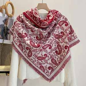 Detail of red and white paisley jacquard scarf with fine fringe on a white tweed jacket