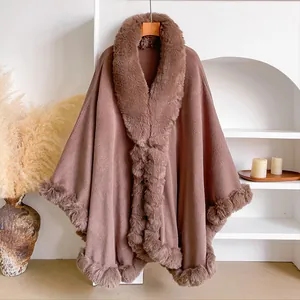 Detail of faux fur trim on warm brown oversized knitted poncho cape for women
