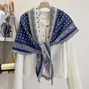 Detail of blue and white geometric diamond jacquard knit scarf with tassel fringe