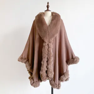 Detail of oversized brown poncho with faux rabbit fur trim on soft wool-like fabric