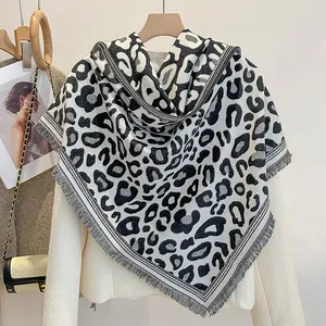 Dettaglio di scialle con stampa leopardata, frange e outfit con blazer bianco chic