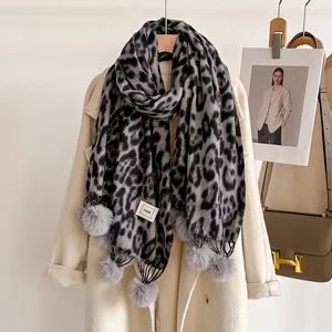 Détail d'écharpe en cachemire à imprimé léopard gris avec pompons et étiquette COOR