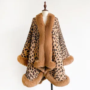 Close-up of leopard jacquard knit cape with thick caramel faux fur trim on white background