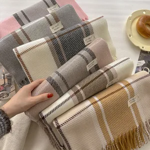 Detail view of colorful plaid wool blend scarves with fringes in various color patterns