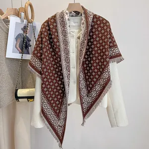 Close-up of geometric jacquard scarf with tassels on cream tweed jacket