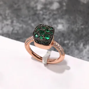 Primer plano detallado de un anillo de esmeralda en oro rosa con malla de panal y diamantes