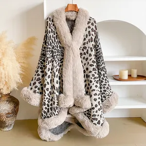 Detail of leopard print shawl with beige faux fur collar hanging on a wooden hanger