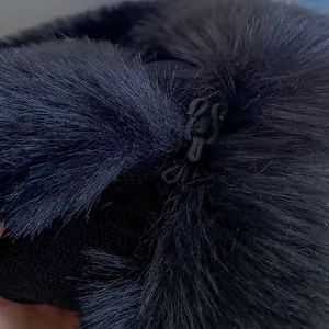 Detailed close-up of the thick black faux fur texture and Chinese knot closure on the hood