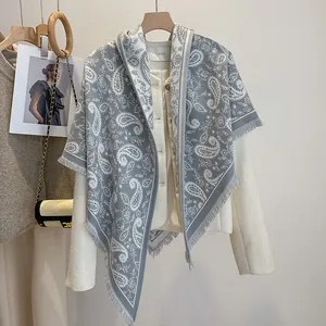 Detail of grey paisley pattern shawl with fringe paired with cream tweed jacket