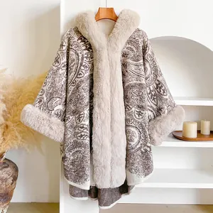 Detail showing paisley patterns and plush faux fur trim on the ivory beige poncho cloak