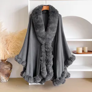 Detail of dark grey poncho with plush faux rabbit fur trim and premium wool fabric