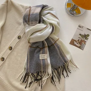 Detailed close-up of wool blend plaid scarf with tassels and brand washing label