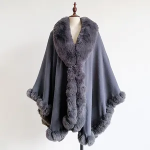 Detail showing plush faux rabbit fur collar and thick grey fabric texture of the poncho