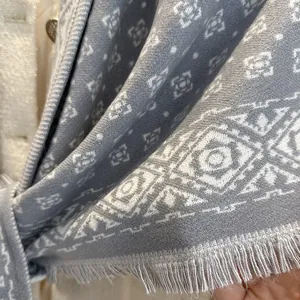 Blue-grey geometric jacquard knit scarf with long tassels and minimalist diamond pattern