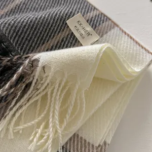 Detailed view of the plaid wool blend scarf fabric texture with delicate fringe edge